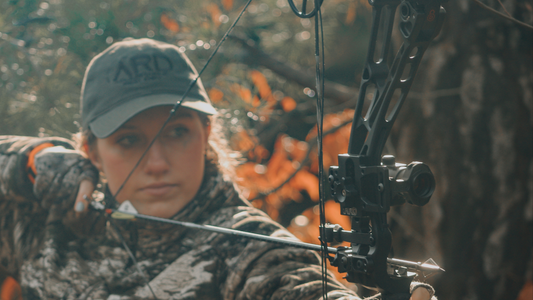 Woman hunter using a Bowtech Solution SD bow in Huntworth gear and using ARD bow sight.